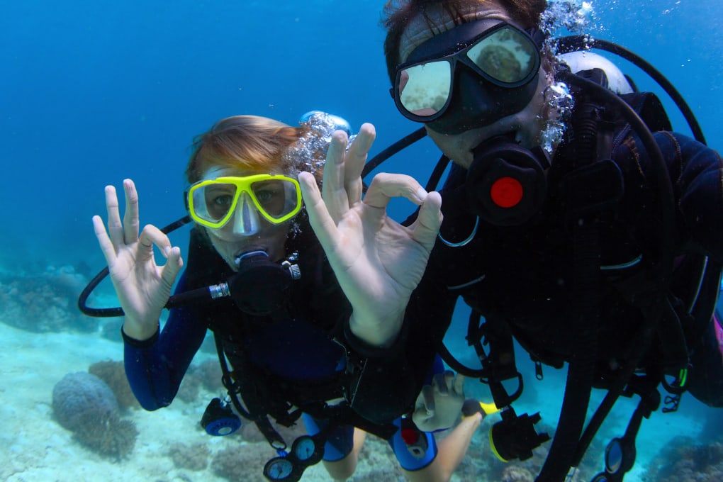 Couple showing the scuba fine sign