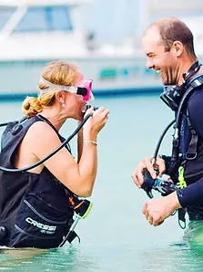 A woman and man preparing to scuba dive